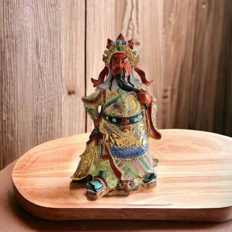 Eine Statue eines chinesischen Gottes, der auf einem Holztisch sitzt.