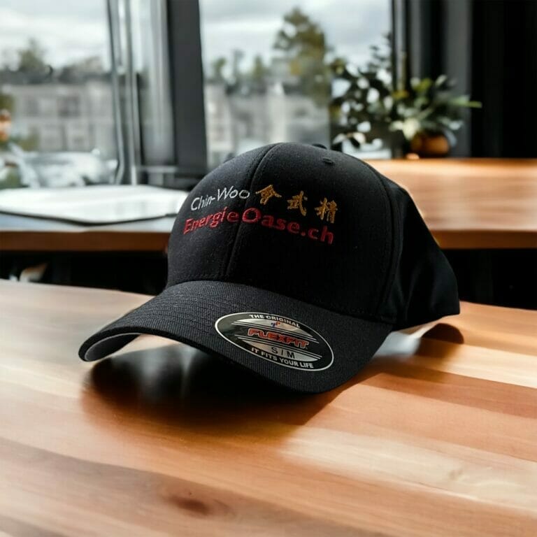 Auf einem Tisch liegt ein schwarzer Hut mit rotem Logo.