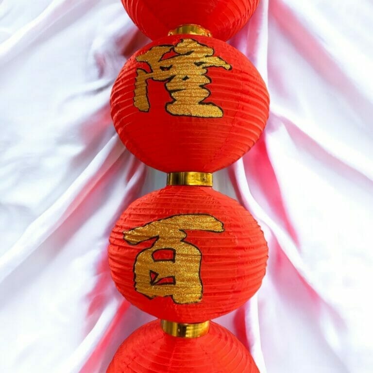 Rote Papierlaternen mit chinesischer Schrift darauf.