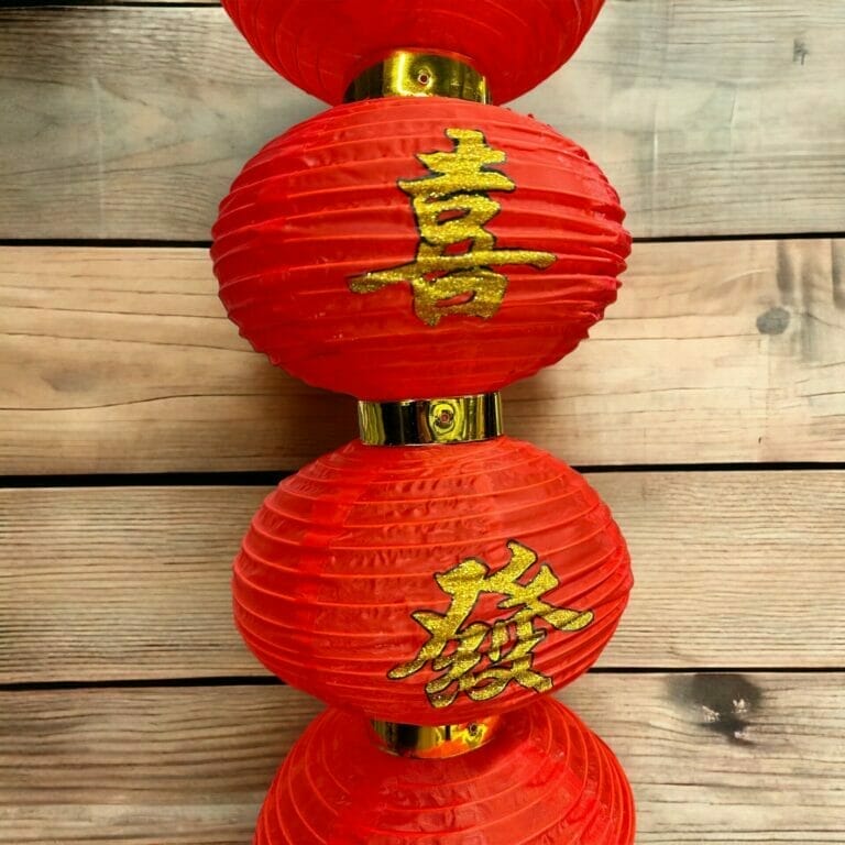 Drei rote Papierlaternen mit chinesischer Schrift darauf.